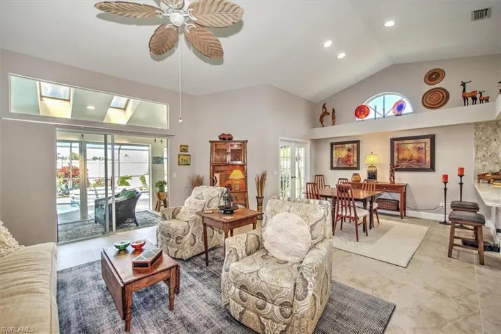 Living area with visible vents, high vaulted ceiling, a skylight, recessed lighting, and ceiling fan
