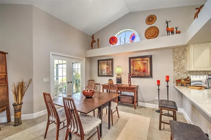 Dining room featuring french doors, baseboards, and high vaulted ceiling