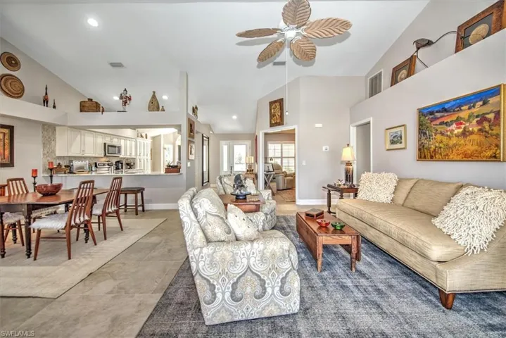 Living area with visible vents, baseboards, recessed lighting, high vaulted ceiling, and a ceiling fan