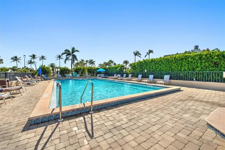 Community pool featuring a patio and fence