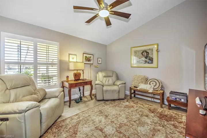 Sitting room featuring baseboards, ceiling fan, and vaulted ceiling