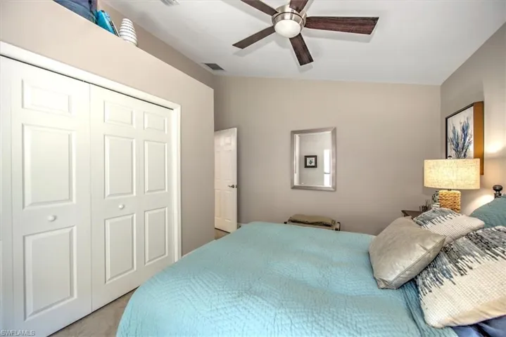 Bedroom with visible vents, lofted ceiling, a closet, and ceiling fan