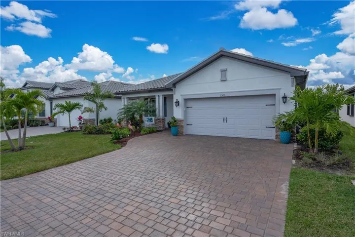 View of front of home with a garage and a front lawn
