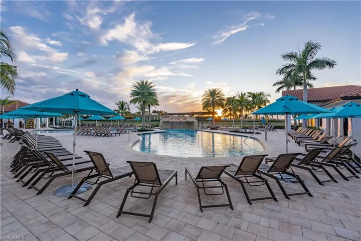 Pool at dusk featuring a patio