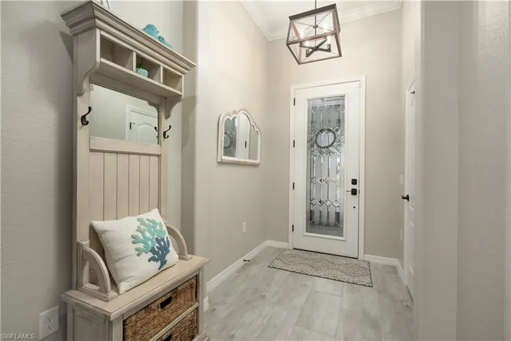 Mudroom with ornamental molding and light hardwood / wood-style floors