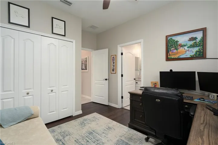 Office area with ceiling fan and dark wood-type flooring