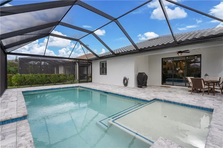 View of pool with a patio and glass enclosure