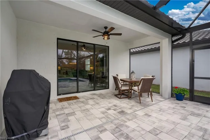 View of patio featuring grilling area, ceiling fan, and glass enclosure