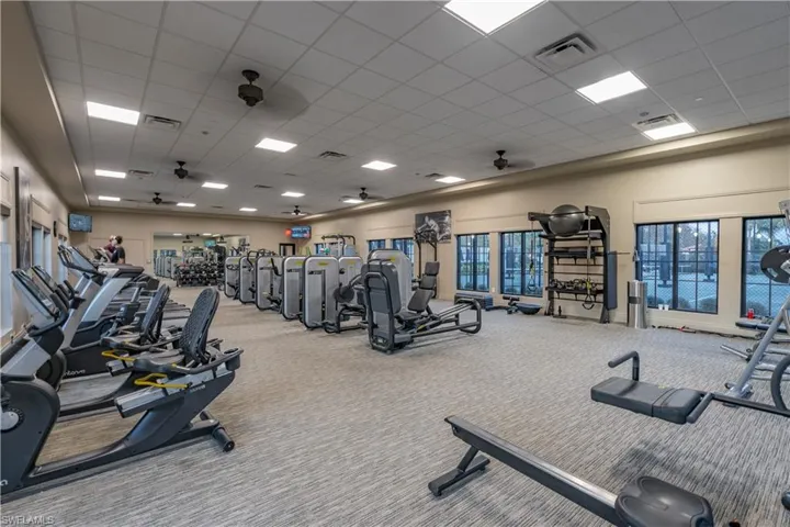 Exercise room featuring a drop ceiling, carpet floors, and ceiling fan
