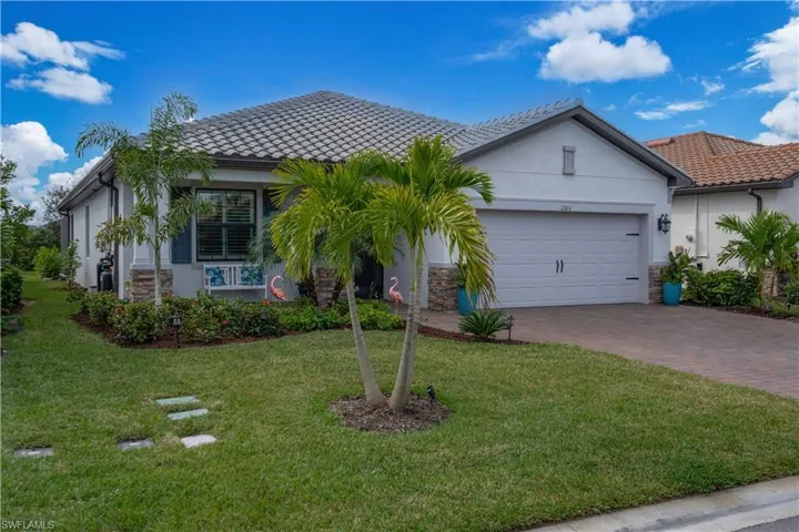 View of front of home with a garage and a front yard