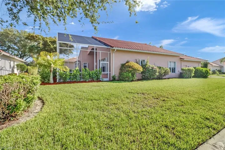 Rear view of property featuring a lawn and a lanai