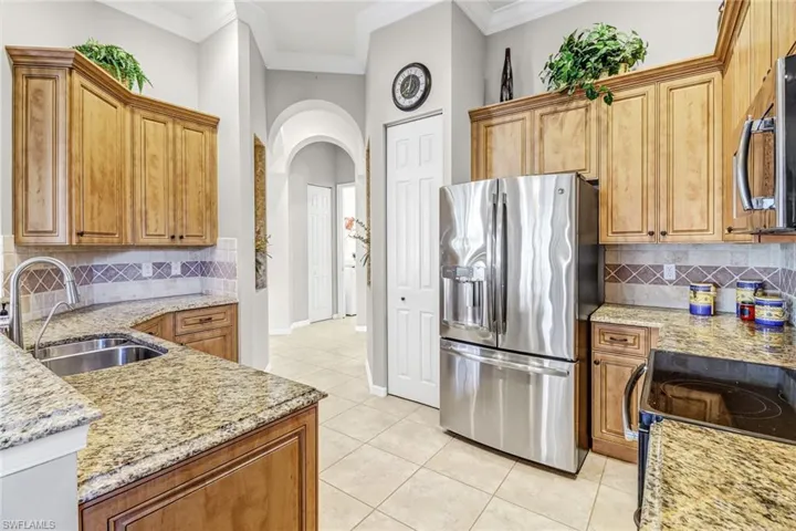 Kitchen featuring stainless steel appliances, backsplash, sink, and ornamental molding