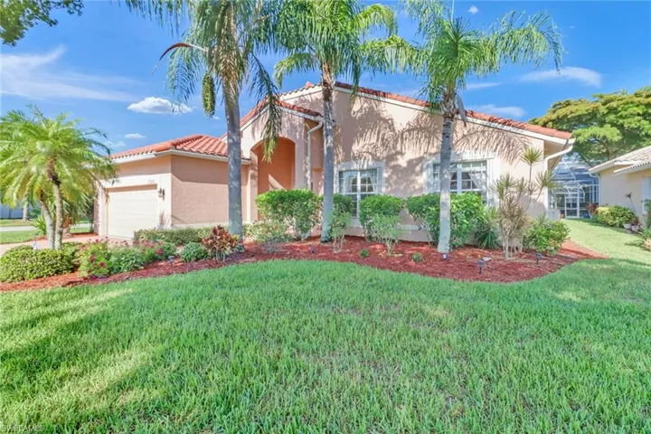 Mediterranean / spanish-style home featuring a garage and a front lawn