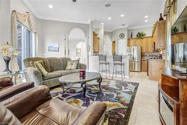 Living room featuring crown molding and light tile flooring