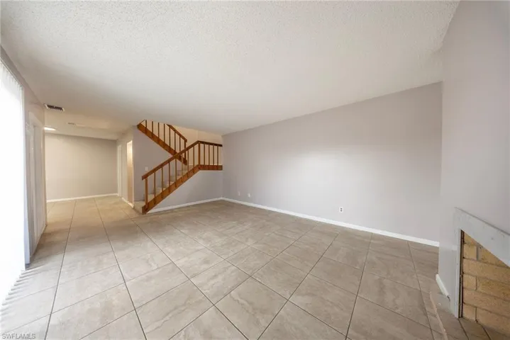 Unfurnished room featuring a textured ceiling and light tile patterned floors