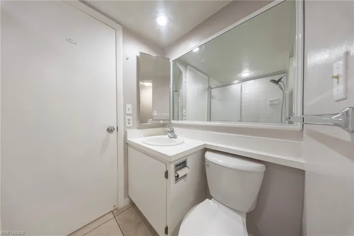 Full bathroom with vanity, light tile patterned flooring, and a shower with door