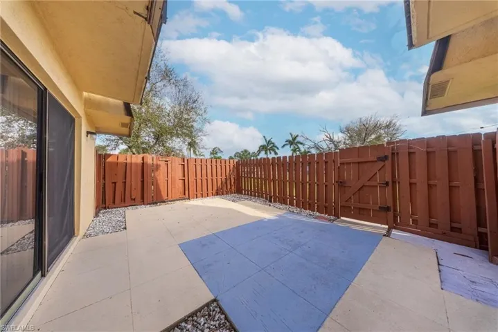 Fenced backyard featuring a gate and a patio