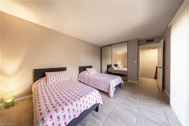 Bedroom with a closet, a textured ceiling, and light tile patterned floors