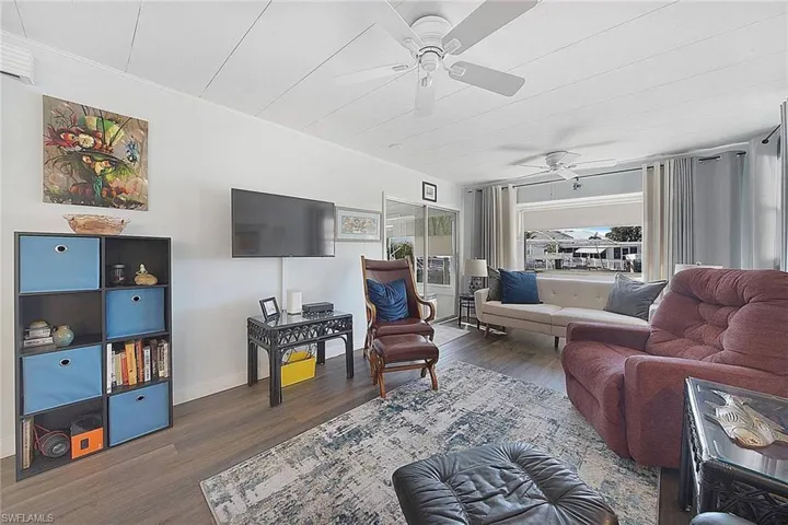 Living room with dark hardwood / wood-style floors and ceiling fan
