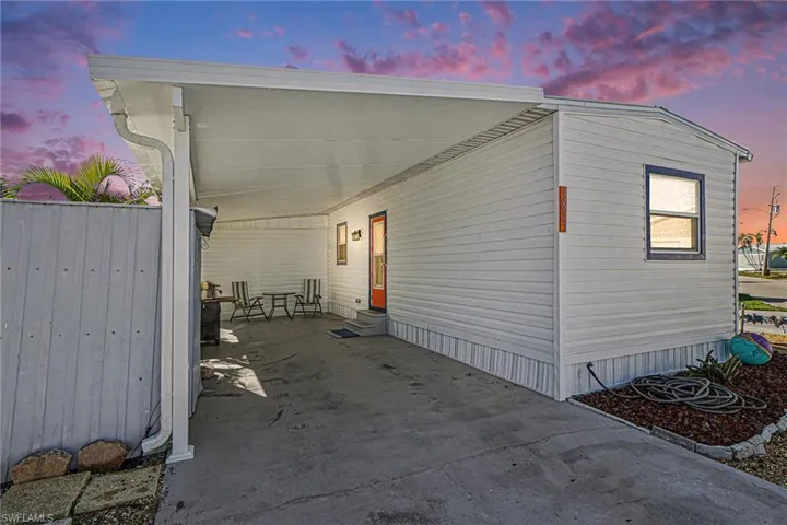 View of side of home featuring an attached new carport and entry steps
