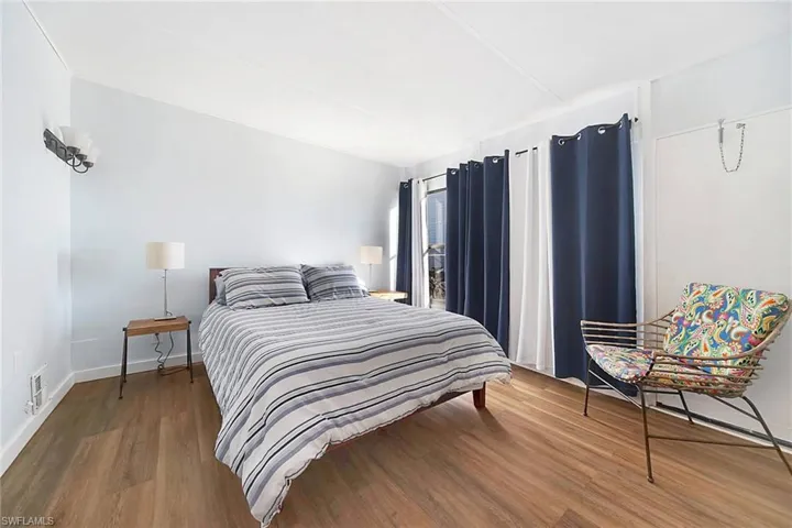 Bedroom with wood-style floors and fan.