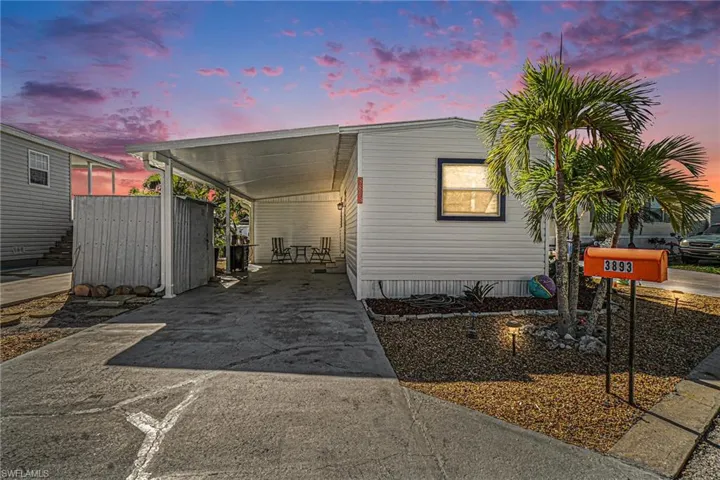 Manufactured / mobile home with concrete driveway and a carport