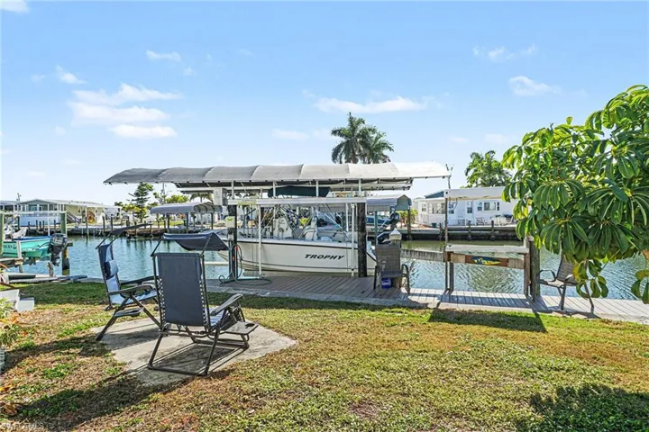 Dock featuring a water view, a yard, and boat lift