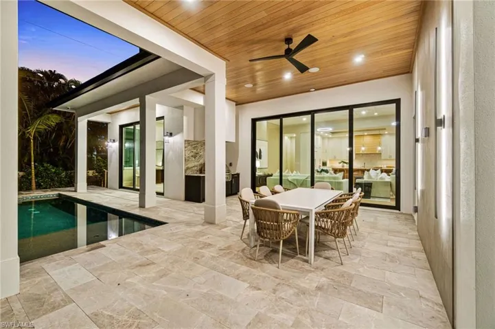 Sunroom / solarium with a swimming pool, wood ceiling, and ceiling fan