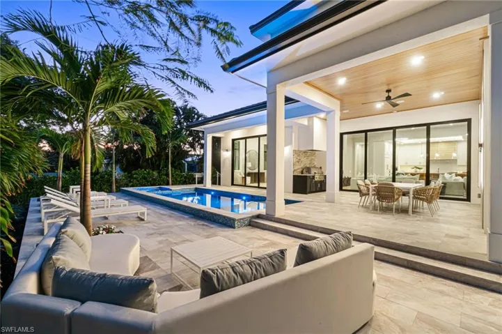Pool at dusk featuring ceiling fan, an outdoor hangout area, and a patio area