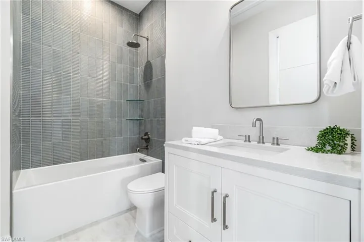 Full bathroom featuring tiled shower / bath, toilet, and vanity