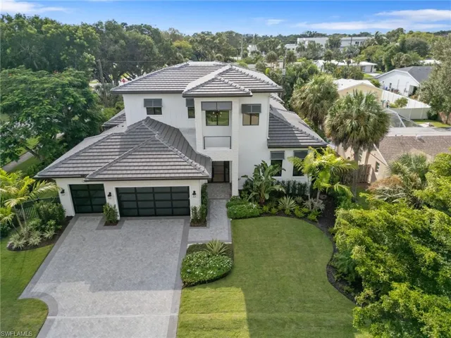 View of front of home with a garage and a front lawn