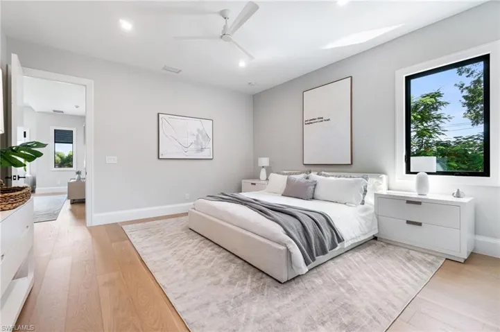 Bedroom with light hardwood / wood-style flooring, multiple windows, and ceiling fan