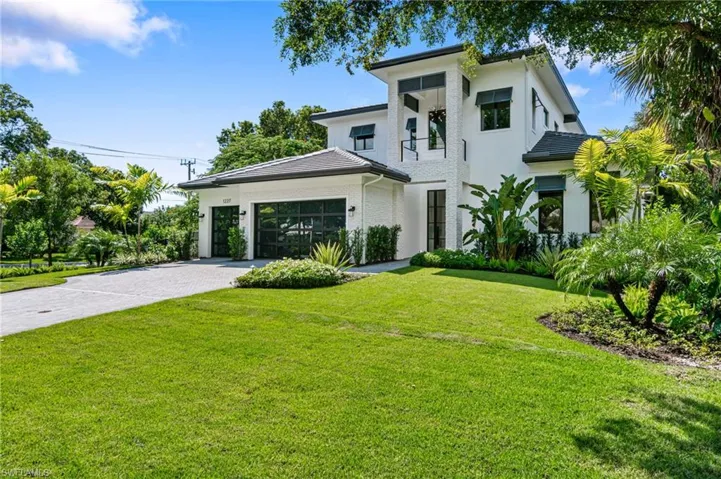 View of front of home with a garage and a front lawn