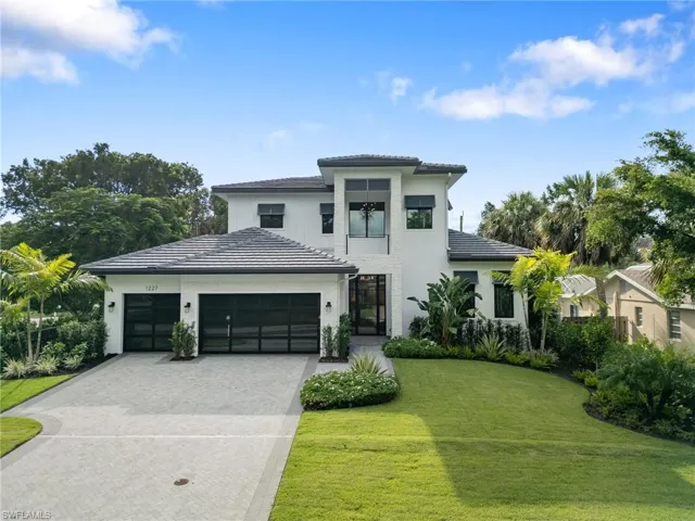 View of front of property with a front lawn and a garage