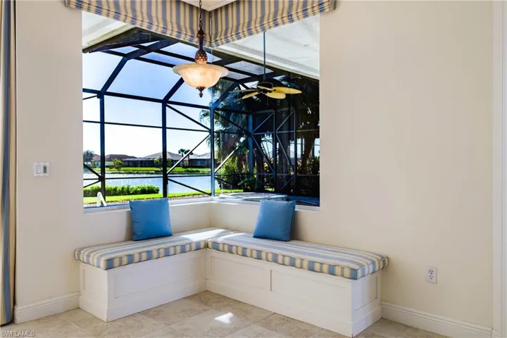 Detailed view of breakfast nook, stucco siding, ceiling fan, and nearby water