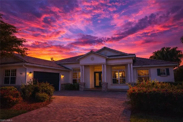 View of front of home featuring a garage, decorative driveway, stucco siding, and a porch