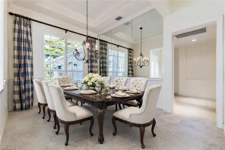 Dining space Staged featuring a tray ceiling, a chandelier, and ornamental molding