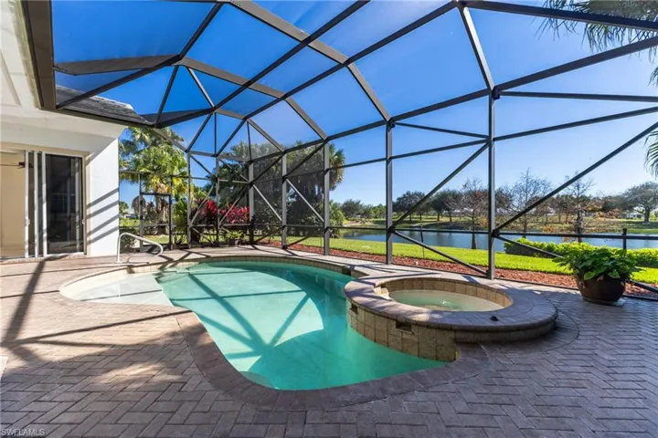 View of swimming pool with glass enclosure, a patio area, and a sunroom