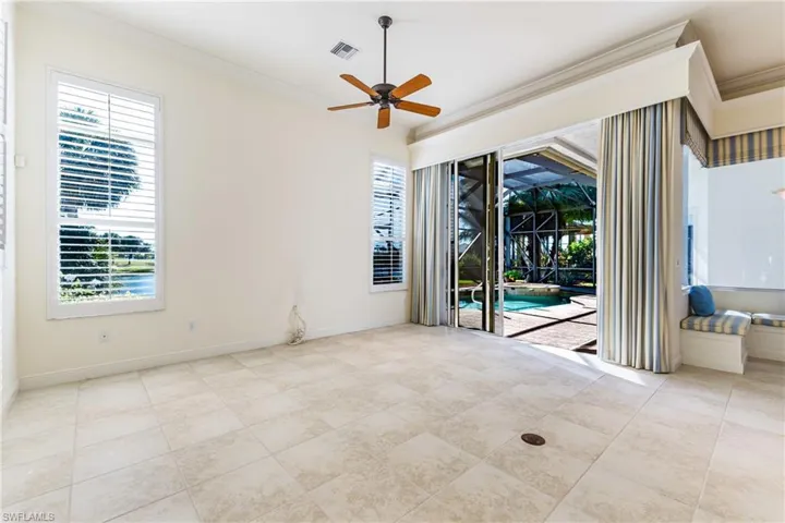 Unfurnished family room featuring ornamental molding, a sunroom, healthy amount of natural light, ceiling fan, and light tile patterned floors