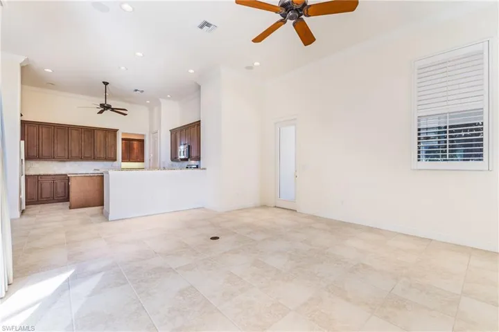 Unfurnished family room featuring a ceiling fan, ornamental molding, a high ceiling, and recessed lighting