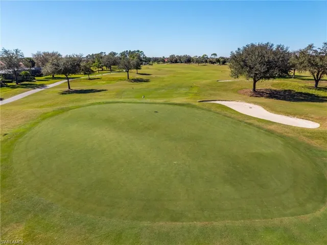 Surrounding community with view of golf course and a yard