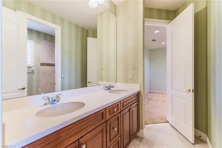 Bathroom featuring double vanity and light tile patterned floors