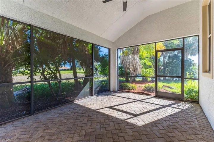 Unfurnished sunroom featuring lofted ceiling and ceiling fan