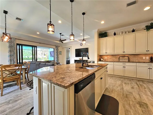 Kitchen with a sink, visible vents, open floor plan, and stainless steel dishwasher