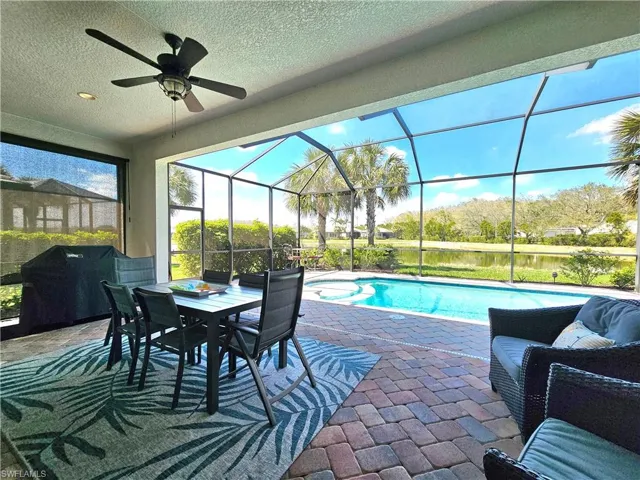 Outdoor pool featuring ceiling fan, outdoor dining space, a patio area, and a lanai