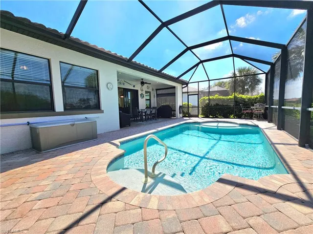 Outdoor pool with a ceiling fan, a lanai, and a patio
