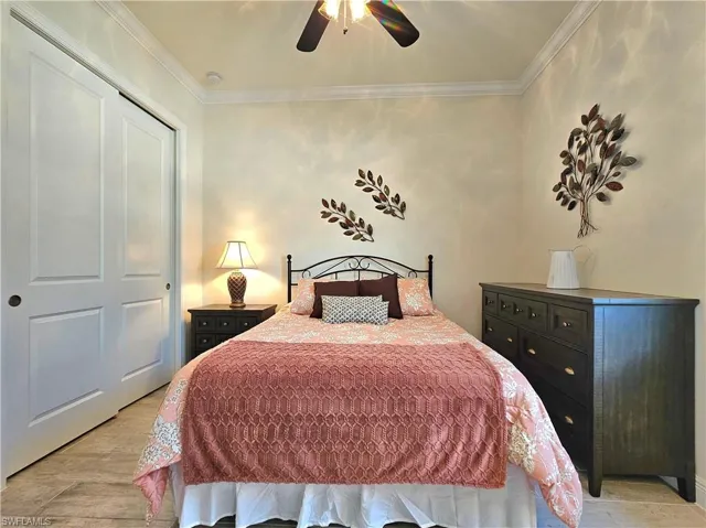 Bedroom with a ceiling fan, crown molding, and light wood-style tile flooring