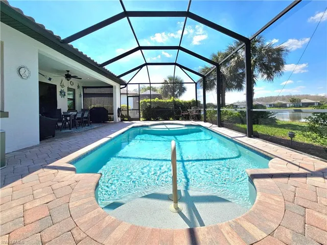Pool with a patio area, glass enclosure, and a ceiling fan