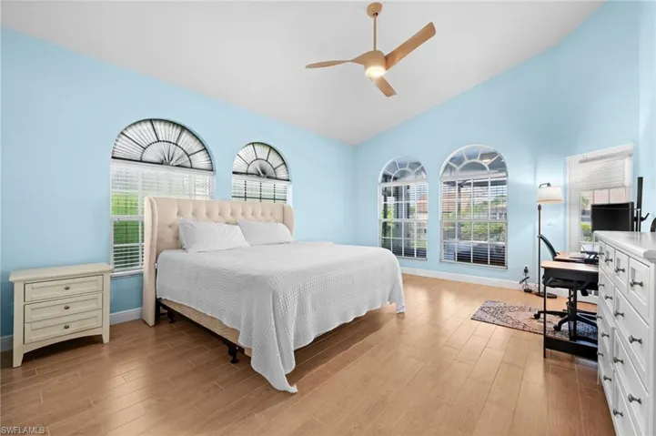 Bedroom featuring light hardwood / wood-style floors, vaulted ceiling, and ceiling fan