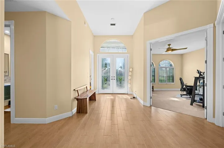 Carpeted entryway featuring ceiling fan and french doors